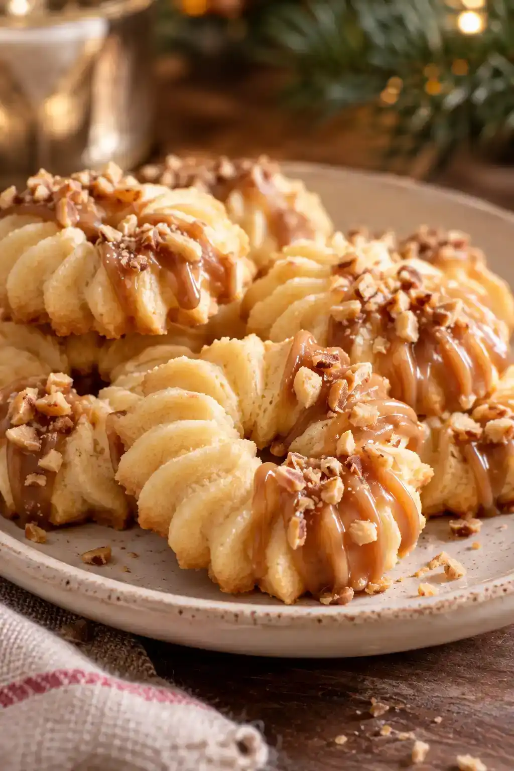 A batch of salted caramel spritz cookies arranged on a ceramic plate.