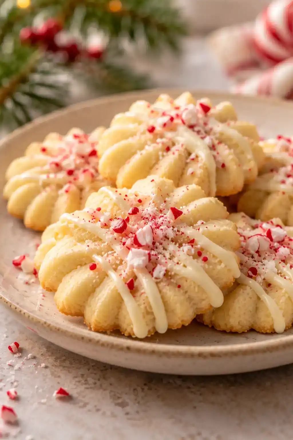 A batch of white chocolate peppermint spritz cookies arranged on a ceramic plate.